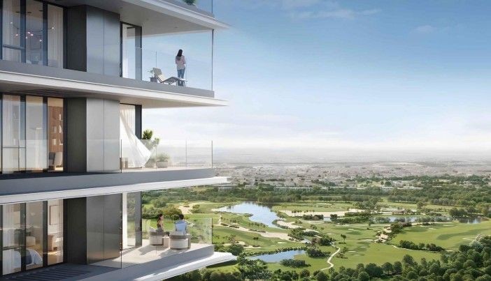 Modern high-rise building with balconies overlooking a scenic golf course and lush greenery on a clear day.